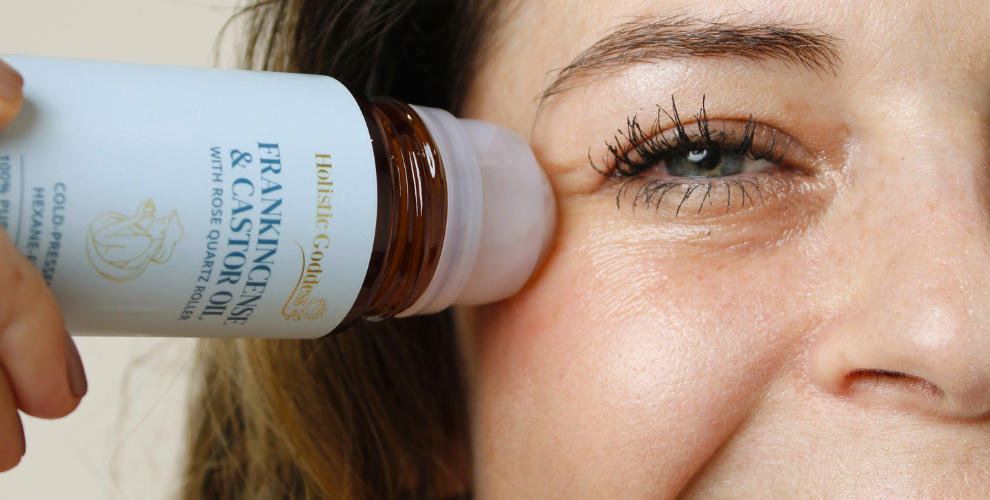 Women apply Frankincense & Castor Oil Roll-on by eye