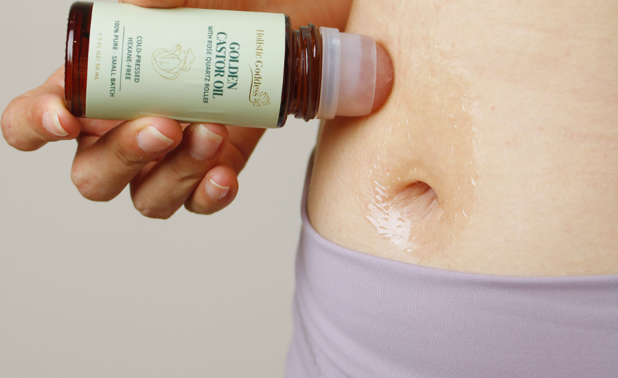 Women applying Golden Castor Oil Roll-on over belly and naval