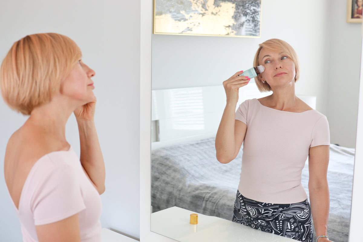 Woman applying Castor Oil + Frankincense Roll-On in undereye area for puffiness