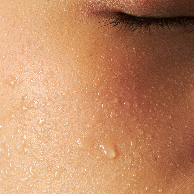 Close-up of a person's face with water droplets on skin