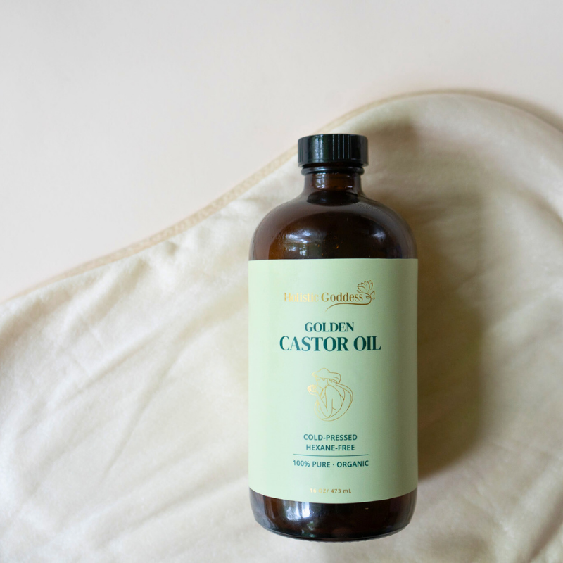 Golden Castor Oil bottle resting on a cream castor oil pack for liver
