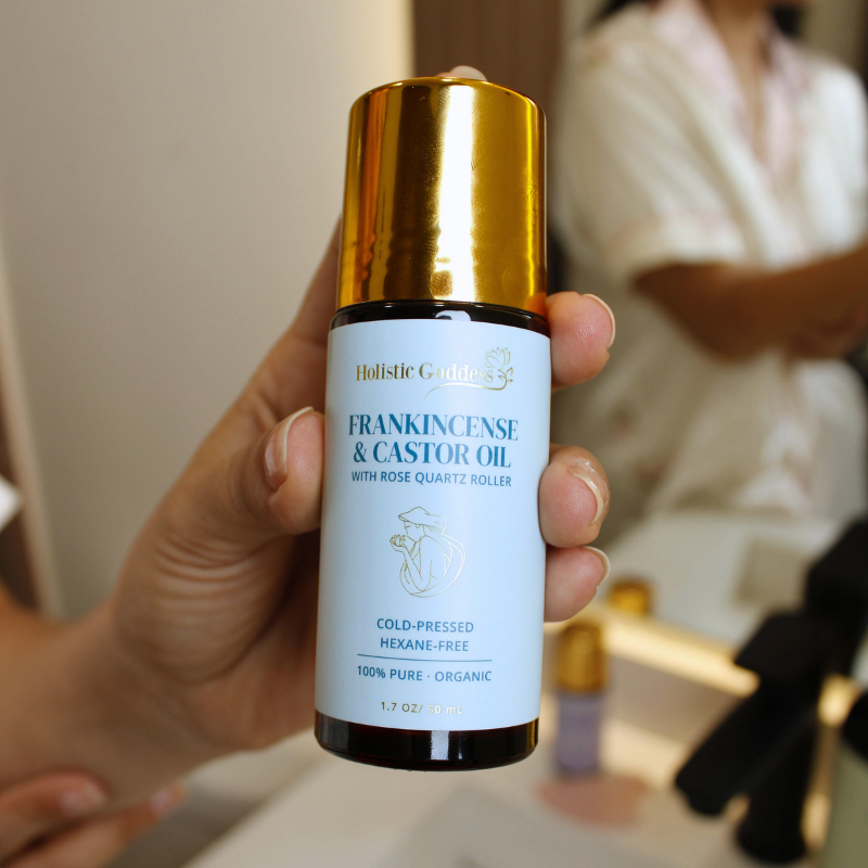 Frankincense Gua Sha Contour Kit – hand holding Frankincense and Castor Oil bottle with Rose Quartz Roller, bathroom lifes...