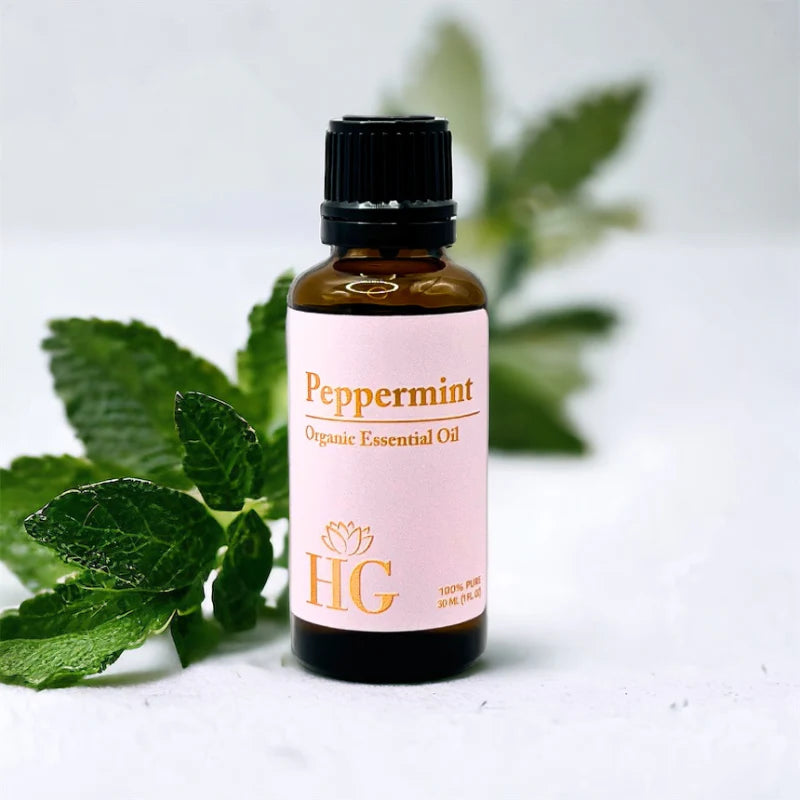 Organic Essential Oil Kit by Holistic Goddess – Peppermint bottle styled with fresh mint leaves, lifestyle product shot