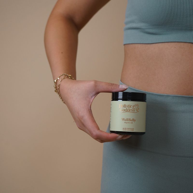 WellBelly by Holistic Goddess – woman holding jar against her hip, cropped lifestyle photo